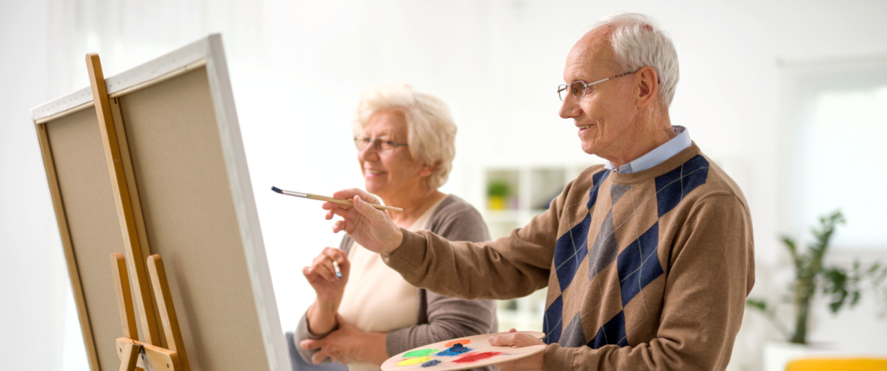 Older man and woman paint together